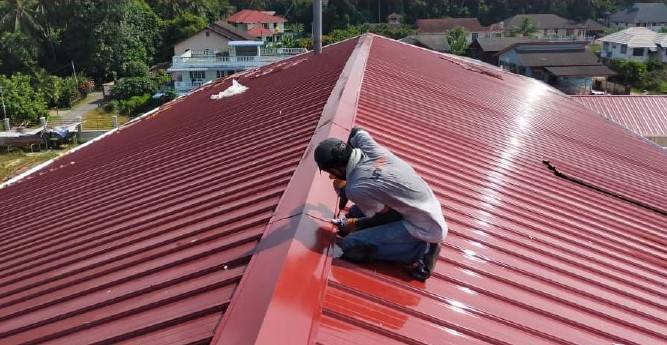 Roofer installing a metal roof — OKG Roof & Truss Engineering
